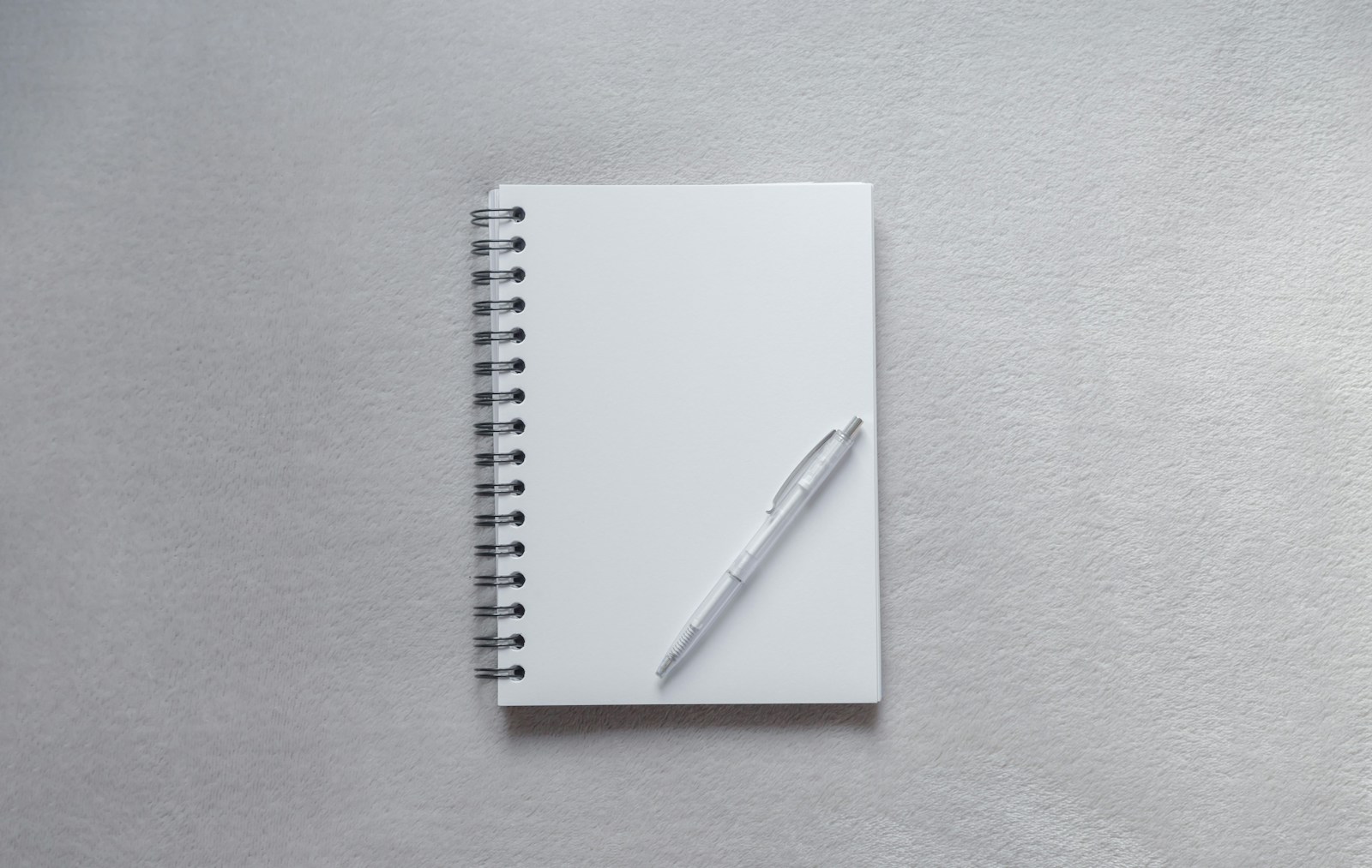 white notebook with pen on top